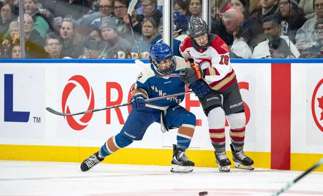 Vancouver Goldeneyes' Sydney Bard (11) and Ottawa Charge's Katerina Mrazova (16) vie for the puck during the third period of a PWHL hockey game in Vancouver, British Columbia, Saturday, March 14, 2026. (Ethan Cairns/The Canadian Press via AP)