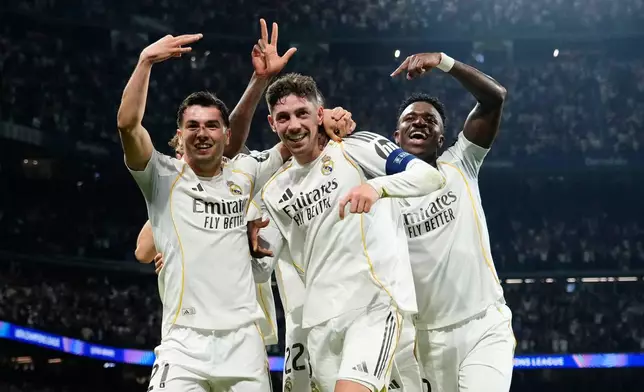 Real Madrid's Federico Valverde, center, celebrates after scoring his third goal during a first leg round of 16 Champions League soccer match between Real Madrid and Manchester City in Madrid, Spain, Wednesday, March 11, 2026. (AP Photo/Jose Breton)