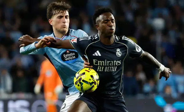 Real Madrid's Vinicius Junior, duels for the balls with Celta's Javi Rodriguez during a Spanish La Liga soccer match between Celta Vigo and Real Madrid in Vigo, Spain, Friday, March 6, 2026. (AP Photo/Lalo R. Villar)