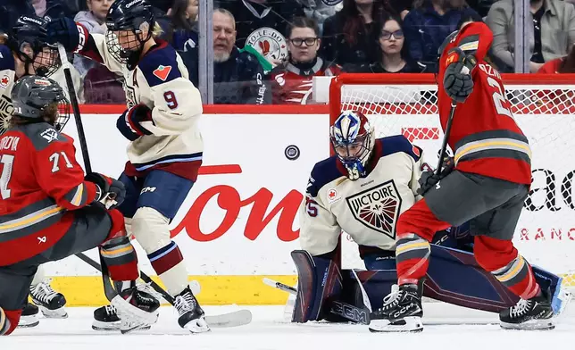 Ottawa Charge's Sarah Wozniewicz (23) looks for the rebound as Montreal Victoire goaltender Ann-Renee Desbiens (35) saves the shot during first period PWHL hockey game action in Winnipeg, Canada, Sunday, March 22, 2026. (John Woods/The Canadian Press via AP)