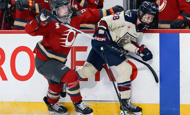 Ottawa Charge's Rory Guilday (5) defends against Montreal Victoire's Catherine Dubois (28) during first period PWHL hockey game action in Winnipeg, Canada, Sunday, March 22, 2026. (John Woods/The Canadian Press via AP)