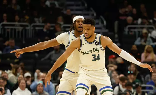 Milwaukee Bucks forward Giannis Antetokounmpo (34) and Myles Turner play defense against the Atlanta Hawks during the first half of an NBA basketball game Wednesday, March 4, 2026, in Milwaukee. (AP Photo/Jeffrey Phelps)