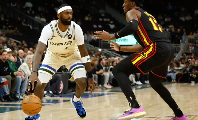 Milwaukee Bucks forward Bobby Portis (9) drives against the Atlanta Hawks' Onyeka Okongwu during the first half of an NBA basketball game, Wednesday, March 4, 2026, in Milwaukee. (AP Photo/Jeffrey Phelps)