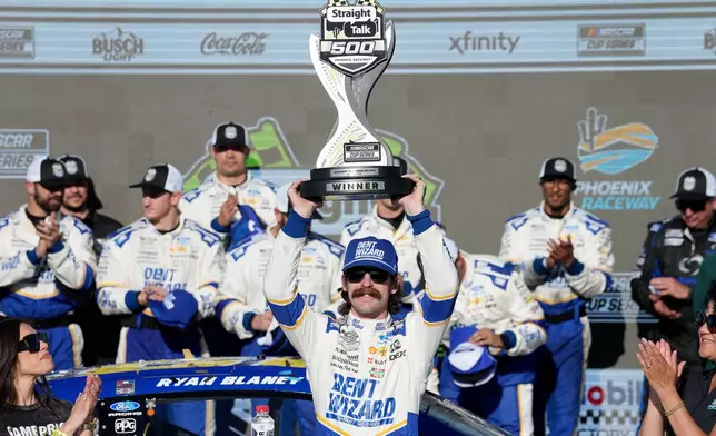 Ryan Blaney hoists the trophy in Victory Lane after winning a NASCAR Cup Series auto race at Phoenix Raceway, Sunday, March 8, 2026, in Avondale, Ariz. (AP Photo/Darryl Webb)