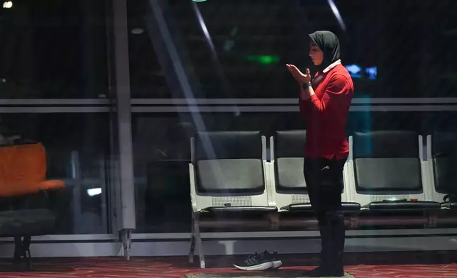 A member of Iran's women's soccer team prays at the Kuala Lumpur International Airport in Sepang, Malaysia, Monday, March 16, 2026. (AP Photo/Azneal Ishak)