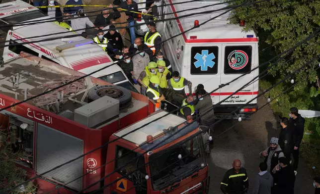 Rescue workers carry a body from an apartment destroyed in an Israeli airstrike in the southern port city of Sidon, Lebanon, Saturday, March 14, 2026. (AP Photo/Mohammad Zaatari)