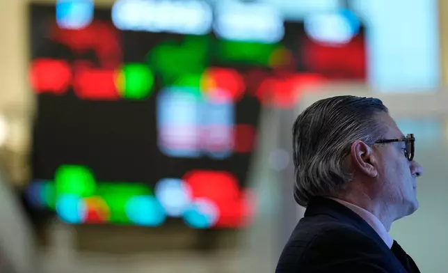 People work on the floor at the New York Stock Exchange in New York, Thursday, March 19, 2026. (AP Photo/Seth Wenig)