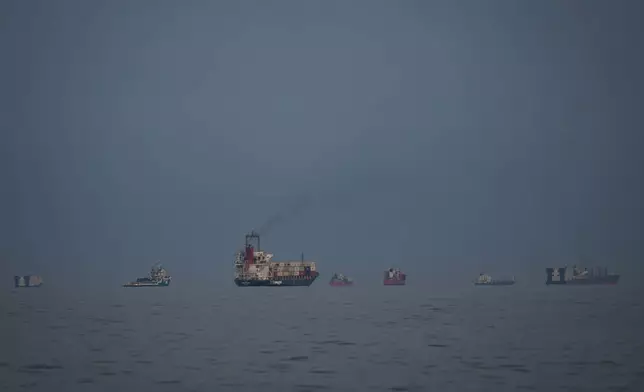 Oil tankers and cargo ships line up in the Strait of Hormuz as seen from Khor Fakkan, United Arab Emirates, Wednesday, March 11, 2026. (AP Photo/Altaf Qadri)
