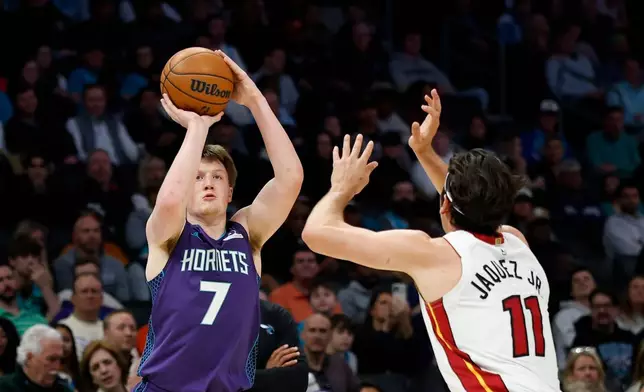 Charlotte Hornets guard Kon Knueppel (7) shoots against Miami Heat forward Jaime Jaquez Jr. during the first half of an NBA basketball game, Tuesday, March 17, 2026, in Charlotte, N.C. (AP Photo/Nell Redmond)