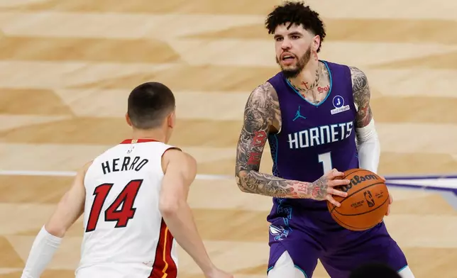 Charlotte Hornets guard LaMelo Ball (1) looks to shoot against Miami Heat guard Tyler Herro during the second half of an NBA basketball game, Tuesday, March 17, 2026, in Charlotte, N.C. (AP Photo/Nell Redmond)