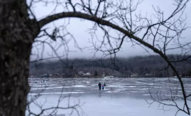 FILE - People ice fish on a frozen Lake Elmore, March 3, 2024, in Elmore, Vt. (AP Photo/David Goldman, File)