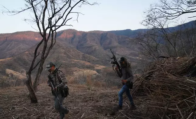 Members of a local self-defense group formed by residents in response to cartel violence stand guard in Guajes de Ayala, Mexico, Tuesday, March 10, 2026. (AP Photo/Marco Ugarte)