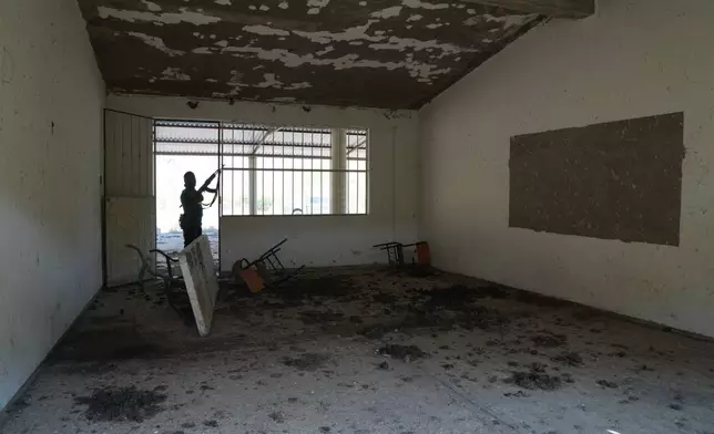 A member of a local self-defense group formed by residents in response to cartel violence guards a closed school in Guajes de Ayala, Mexico, Wednesday, March 11, 2026. (AP Photo/Marco Ugarte)