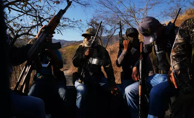 Members of a local self-defense group formed by residents in response to cartel violence patrol in Guajes de Ayala, Mexico, Tuesday, March 10, 2026. (AP Photo/Marco Ugarte)