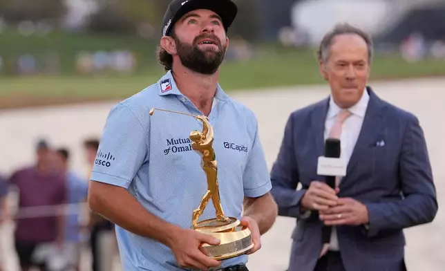 Cameron Young holds the The Players Championship Trophy after winning the final round of The Players Championship golf tournament, Sunday, March 15, 2026, in Ponte Vedra Beach, Fla. (AP Photo/Gerald Herbert)