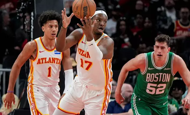 Atlanta Hawks forward Onyeka Okongwu (17) grabs a loose ball against Boston Celtics center Luka Garza (52) in the first half of an NBA basketball game, Monday, March 30, 2026, in Atlanta. (AP Photo/Mike Stewart)