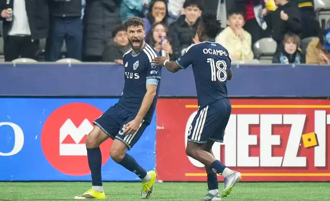 Vancouver Whitecaps' Thomas Muller, left, and Edier Ocampo celebrate Muller's second goal against Toronto FC during the first half of an MLS soccer match, in Vancouver, on Saturday, Feb. 28, 2026. (Darryl Dyck/The Canadian Press via AP)