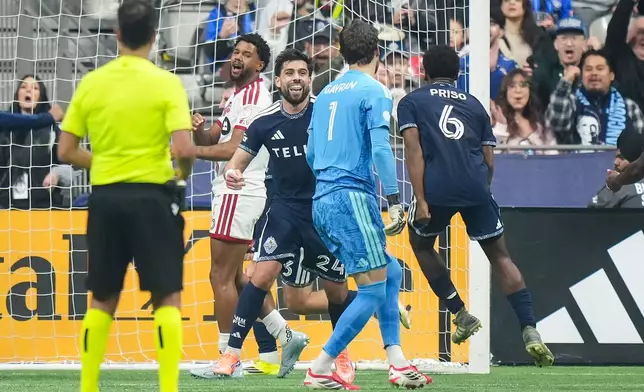 Vancouver Whitecaps' Brian White (24) and Ralph Priso (6) celebrate White's goal against Toronto FC goalkeeper Luka Gavran (1) during the first half of an MLS soccer match, in Vancouver, on Saturday, Feb. 28, 2026. (Darryl Dyck/The Canadian Press via AP)
