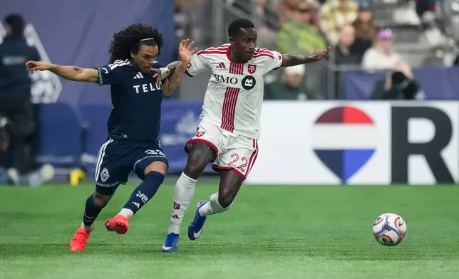 Vancouver Whitecaps' Aziel Jackson, left, and Toronto FC's Richie Laryea vie for the ball during the first half of an MLS soccer match, in Vancouver, on Saturday, Feb. 28, 2026. (Darryl Dyck/The Canadian Press via AP)