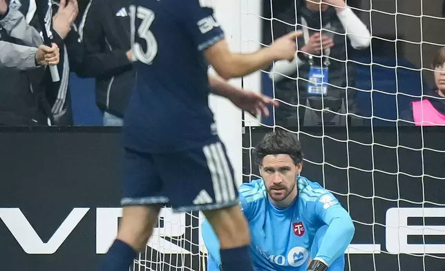 Toronto FC goalkeeper Luka Gavran, back, watches Vancouver Whitecaps' Thomas Muller celebrate his second goal during the first half of an MLS soccer match, in Vancouver, on Saturday, Feb. 28, 2026. (Darryl Dyck/The Canadian Press via AP)