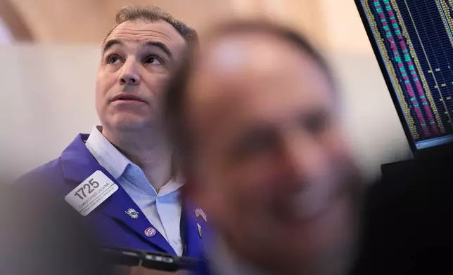 Christopher Lagana works on the floor at the New York Stock Exchange in New York, Monday, March 30, 2026. (AP Photo/Seth Wenig)