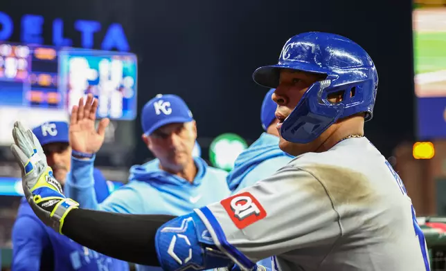 Kansas City Royals' Salvador Perez high-fives teammates in the dugout after hitting a solo home run in the seventh inning of a baseball game against the Atlanta Braves, Saturday, March 28, 2026, in Atlanta. (AP Photo/Colin Hubbard)