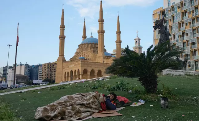 A displaced man who fled Israeli airstrikes in Dahiyeh, Beirut's southern suburbs, sleeps at Martyrs' Square in downtown Beirut, Lebanon, Saturday, March 7, 2026. (AP Photo/Bilal Hussein)
