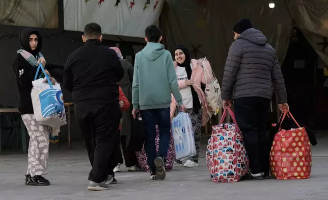 Displaced families fleeing Israeli airstrikes in southern Lebanon arrive at a school turned into a shelter, in Beirut, Lebanon, Monday, March 2, 2026. (AP Photo/Bilal Hussein)