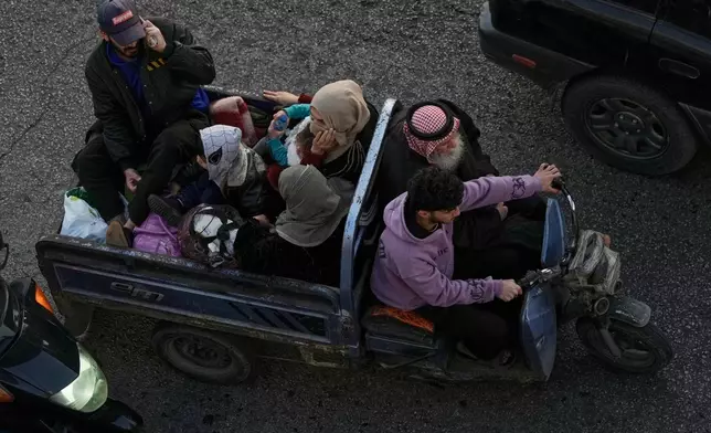 A family flees Israeli airstrikes in Dahiyeh, Beirut's southern suburbs, riding a three-wheeled motorized vehicle known as a "tok-tok," on a highway in Beirut, Lebanon, Thursday, March 5, 2026. (AP Photo/Bilal Hussein)