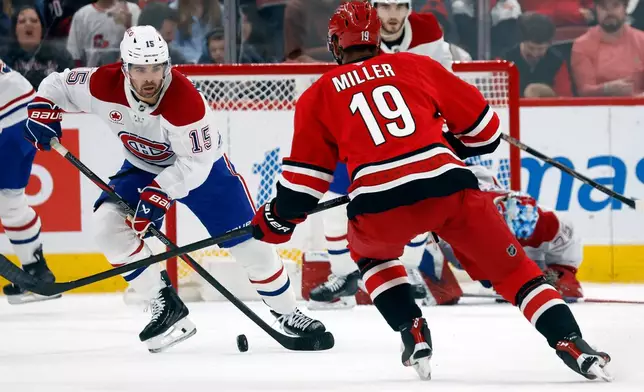 Montréal Canadiens' Alex Newhook (15) controls the puck in front of Carolina Hurricanes' K'andre Miller (19) during the first period of an NHL hockey game in Raleigh, N.C., Sunday, March 29, 2026. (AP Photo/Karl DeBlaker)