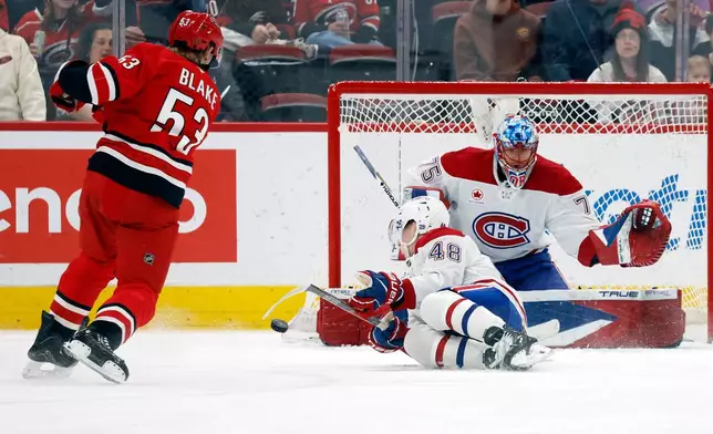 Carolina Hurricanes' Jackson Blake (53) shoots the puck off Montréal Canadiens' Lane Hutson (48) and wide of goaltender Jakub Dobes (75) during the first period of an NHL hockey game in Raleigh, N.C., Sunday, March 29, 2026. (AP Photo/Karl DeBlaker)