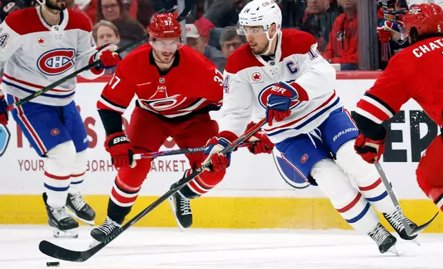 Montréal Canadiens' Nick Suzuki (14) controls the puck against the Montréal Canadiens during the first period of an NHL hockey game in Raleigh, N.C., Sunday, March 29, 2026. (AP Photo/Karl DeBlaker)