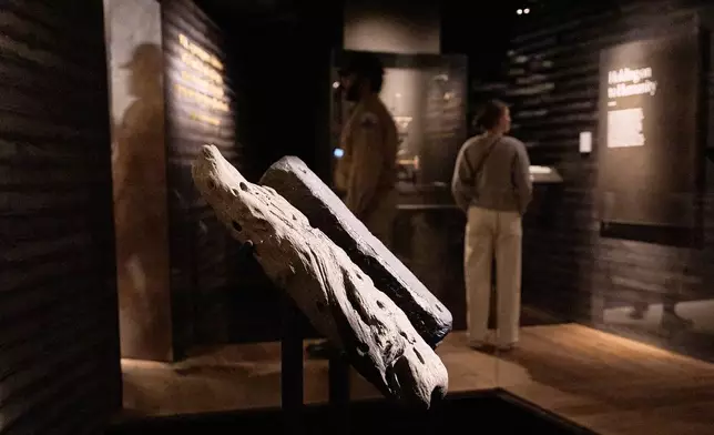 People visit the National Museum of African American History and Culture's Middle Passage exhibit, including a wooden timber, the artifact at left, from the slave ship, the São José-Paquete de Africa, Friday, March 6, 2026, in Washington. (AP Photo/Jacquelyn Martin)