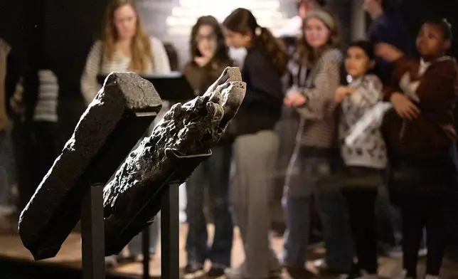 School children visit the National Museum of African American History and Culture's Middle Passage exhibit, behind a wooden timber, the artifact at right, from the slave ship, the São José-Paquete de Africa, Friday, March 6, 2026, in Washington. (AP Photo/Jacquelyn Martin)
