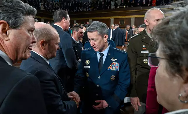 Gen. Dan Caine, chairman of the Joint Chiefs of Staff, greets Sen. Chris Coons, D-Del., before President Donald Trump delivers the State of the Union address to a joint session of Congress in the House chamber at the U.S. Capitol in Washington, Tuesday, Feb. 24, 2026. (Kenny Holston/The New York Times via AP, Pool)