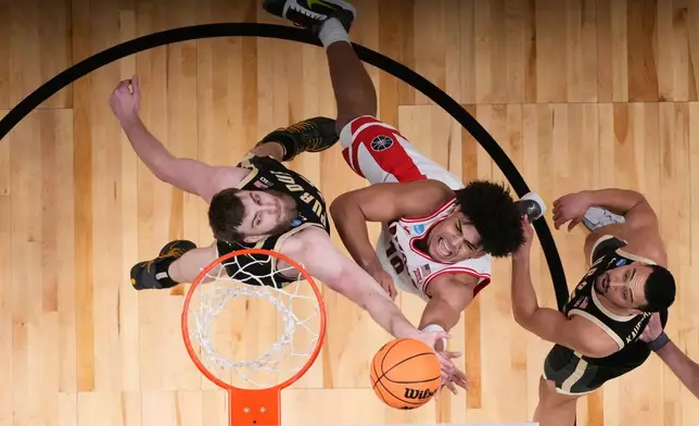 Arizona forward Koa Peat, center, shoots past Purdue center Oscar Cluff, left, during the second half in the Elite Eight of the NCAA college basketball tournament, Saturday, March 28, 2026, in San Jose, Calif. (AP Photo/Godofredo A. Vásquez)