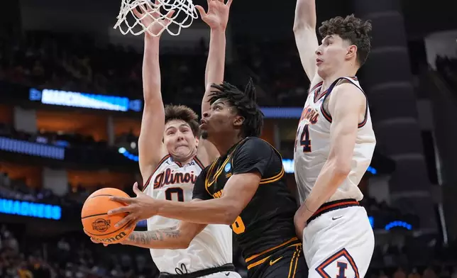 Iowa's Tavion Banks, center, goes up for a shot as Illinois' David Mirkovic (0) and Zvonimir Ivisic defend during the first half of an Elite Eight game in the NCAA college basketball tournament Saturday, March 28, 2026, in Houston. (AP Photo/Eric Gay)