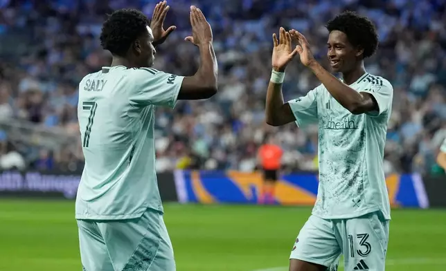Colorado Rapids forward Wayne Frederick (13) celebrates with forward Dante Sealy (7) afte scoring a goal during the first half of an MLS soccer match against Sporting Kansas City, Saturday, March 21, 2026, in Kansas City, Kan. (AP Photo/Charlie Riedel)