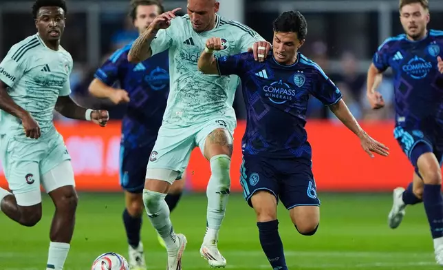 Colorado Rapids forward Rafael Navarro, center left, and Sporting Kansas City midfielder Manu Garcia (6) battle for the ball during the first half of an MLS soccer match Saturday, March 21, 2026, in Kansas City, Kan. (AP Photo/Charlie Riedel)