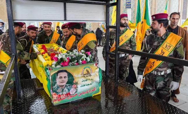 Members from Kataib Hezbollah attend the funeral of their colleagues who were killed in a U.S. airstrike in Qaim province, according to their statement, in Najaf, Iraq, Thursday, March 19, 2026. (AP Photo/Anmar Khalil)