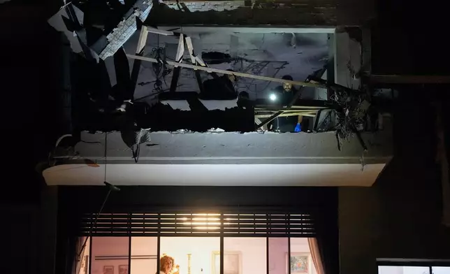 Israeli security forces inspect an apartment struck by an Iranian missile that killed two people in Ramat Gan, Israel, Wednesday, March 18, 2026. (AP Photo/Ohad Zwigenberg)