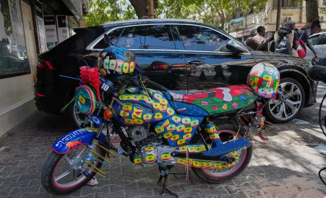 A motorcycle decorated with Senegalese colorful stickers is parked along a street in Dakar, Senegal, Wednesday, March 18, 2026. (AP Photo/Misper Apawu)