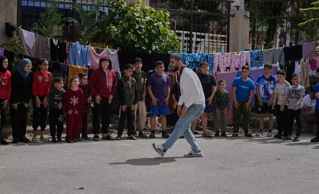 Displaced children who fled Israeli strikes from south Lebanon, take part in activities at a school turned shelter, in the southern port city of Sidon, Lebanon, Wednesday, March 18, 2026. (AP Photo/Mohammed Zaatari)