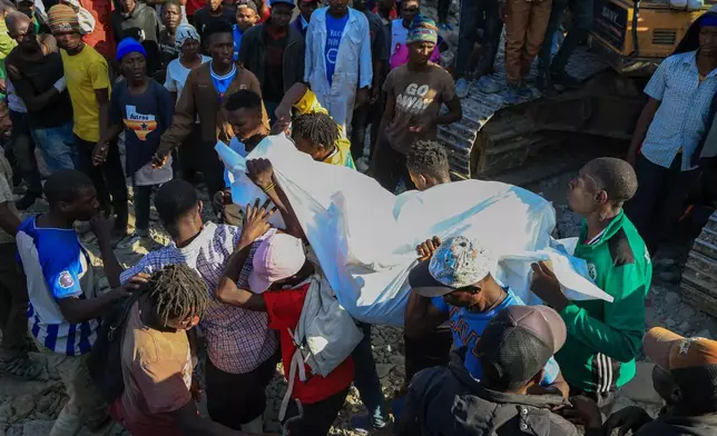 Rescuers carry a victim of a building collapse in Kenya's capital Nairobi, Monday, March 16, 2026. (AP Photo/Andrew Kasuku)