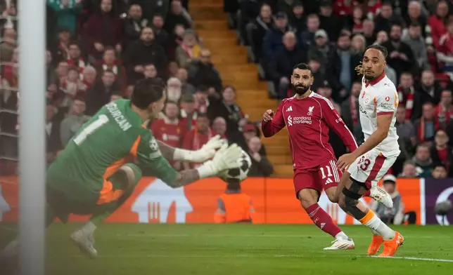 Galatasaray's goalkeeper Ugurcan Cakır, left, makes a save in front of Liverpool's Mohamed Salah, center, during the second leg of the Champions League round of 16 soccer match between Liverpool and Galatasaray, in Liverpool, England, Wednesday, March 18, 2026. (AP Photo/Jon Super)