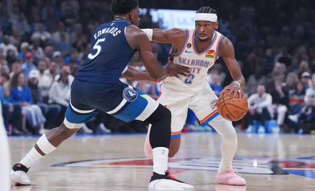 Oklahoma City Thunder guard Shai Gilgeous-Alexander, right, pushes past Minnesota Timberwolves guard Anthony Edwards (5) during the first half of an NBA basketball game, Sunday, March 15, 2026, in Oklahoma City. (AP Photo/Kyle Phillips)