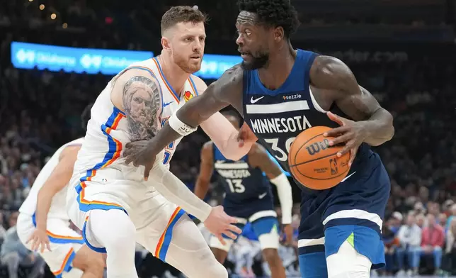 Minnesota Timberwolves forward Julius Randle, right, pushes past Oklahoma City Thunder center Isaiah Hartenstein, left, during the second half of an NBA basketball game, Sunday, March 15, 2026, in Oklahoma City. (AP Photo/Kyle Phillips)
