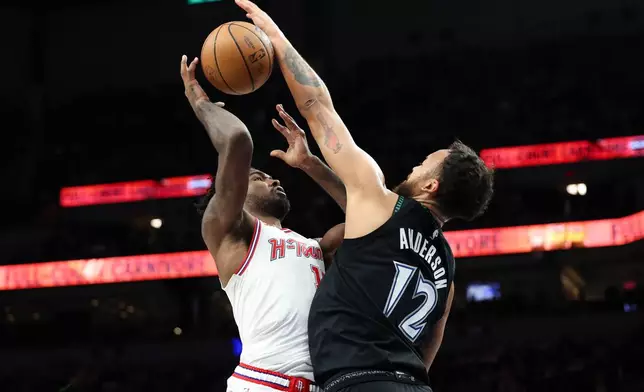 Houston Rockets forward Tari Eason (17) shoots while Minnesota Timberwolves forward Kyle Anderson (12) blocks during the first half of an NBA basketball game, Wednesday, March 25, 2026, in Minneapolis. (AP Photo/Ellen Schmidt)