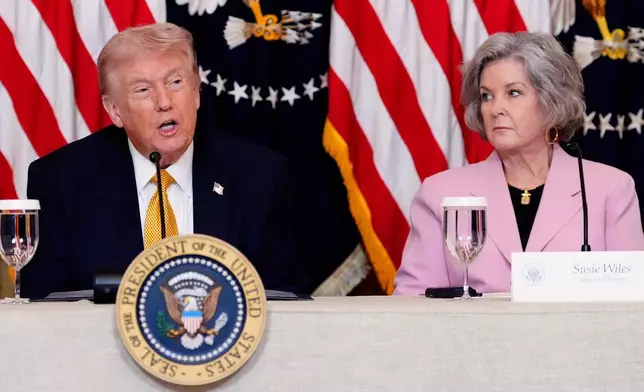 President Donald Trump speaks during a board meeting of the John F. Kennedy Memorial Center For The Performing Arts in the East Room of the White House, Monday, March 16, 2026, in Washington, as White House Chief of Staff Susie Wiles, looks on. (AP Photo/Alex Brandon)