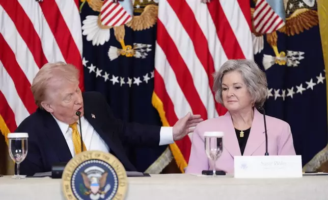 President Donald Trump speaks next to White House Chief of Staff Susie Wiles during a board meeting of the John F. Kennedy Memorial Center For The Performing Arts in the East Room of the White House, Monday, March 16, 2026, in Washington. (AP Photo/Alex Brandon)